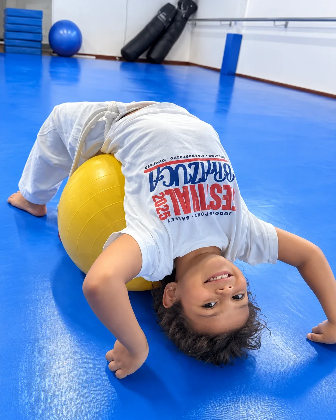 Criança fazendo exercício na aula de capoeira infantil