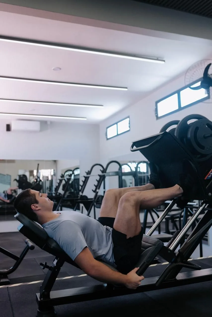 Aluno treinando no leg press da sala de musculação