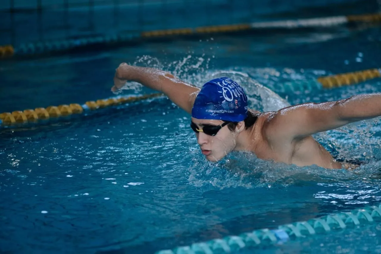 Aluno nadando borboleta na piscina da academia