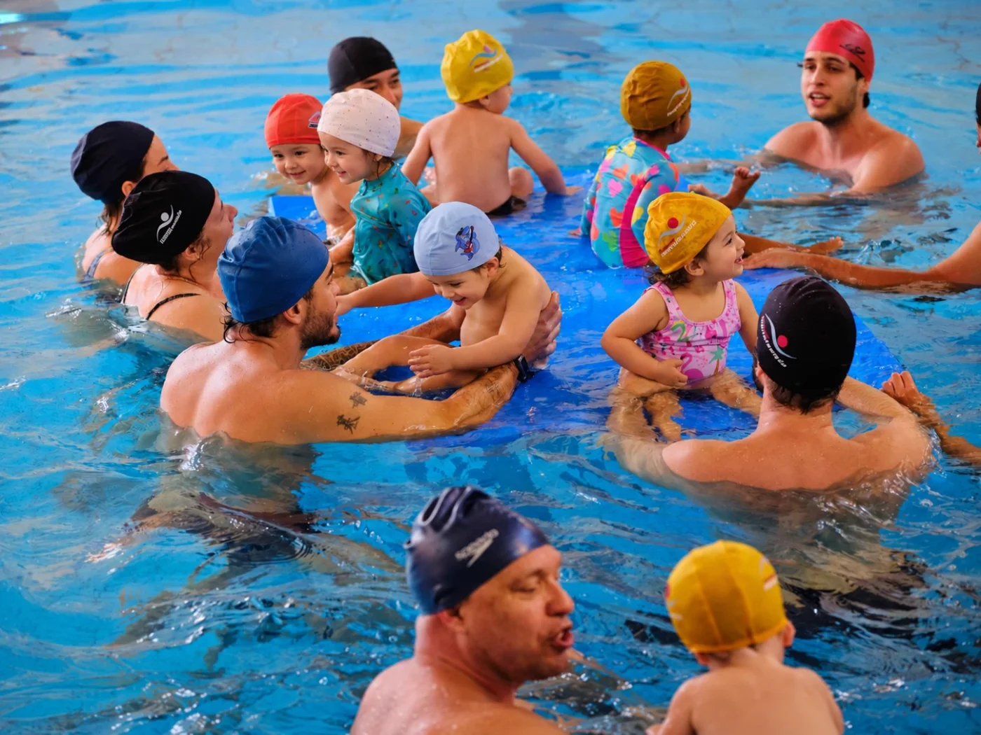 Aula de natação infantil com professores na piscina